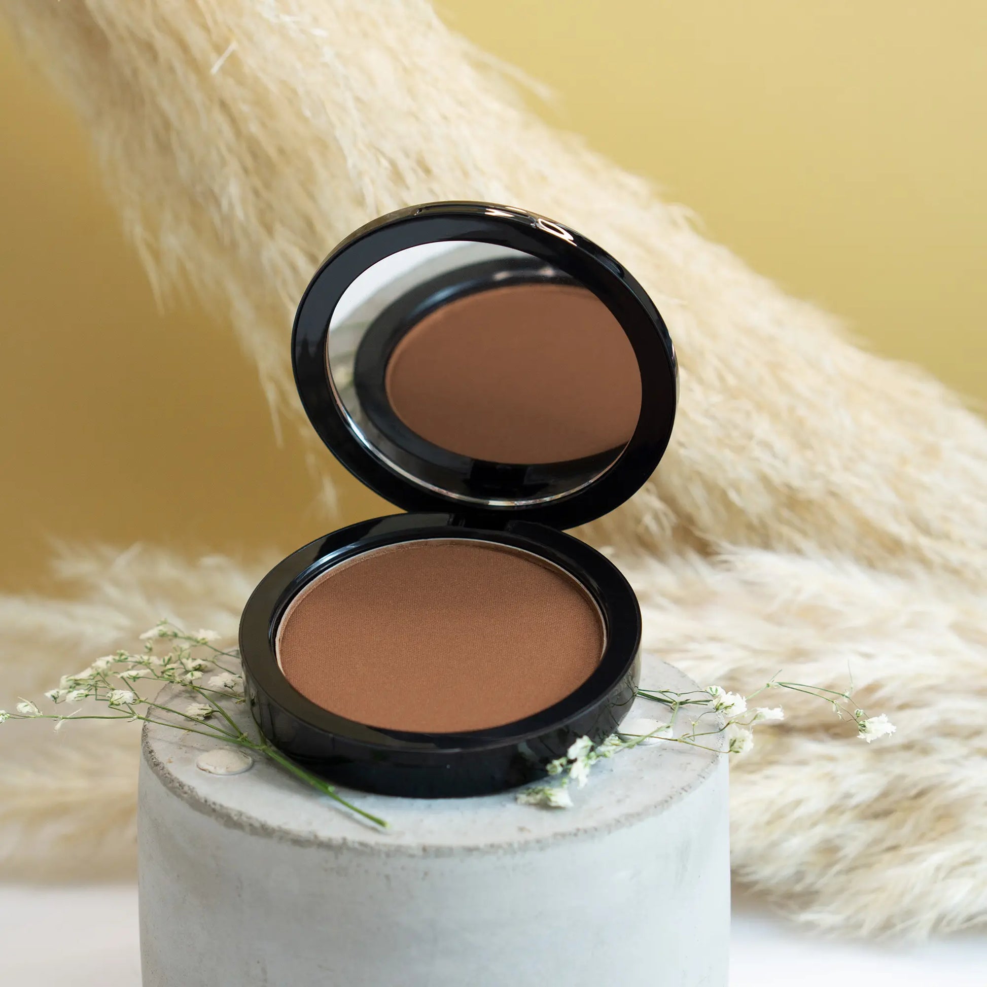 “Balanced red-brown bronzer shade creating sun-kissed skin finish”